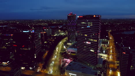 City-skyline-office-buildings-district,-aerial-drone-scene-at-night,-Bucharest,-Romania