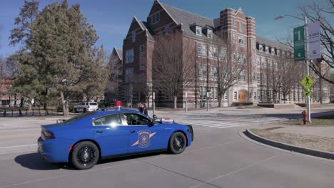 Berkey-Hall-Auf-Dem-Campus-Der-Michigan-State-University-Mit-Einem-Polizeiauto-Davor-Und-Studenten,-Die-Spazieren-Gehen