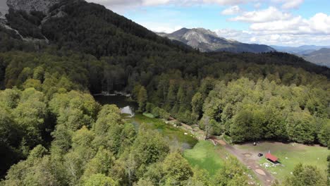 Revealing-drone-video-shot-alpine-lake-Moutsalia-mountain-Gramos-Greece-tilt-down
