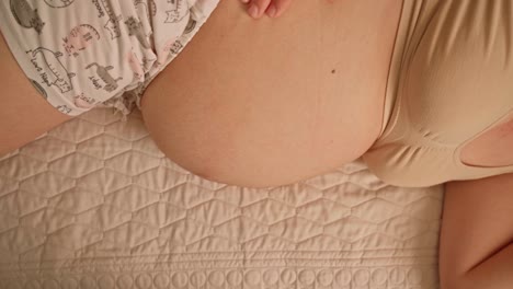 Pregnant-woman-lying-on-her-side-in-bed-for-comfort-during-pregnancy