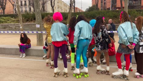 Eine-Reihe-Von-Skater-Mädchen-In-Kostümen-Bereiten-Sich-Darauf-Vor,-Beim-Straßenkarneval-Schlittschuh-Zu-Laufen