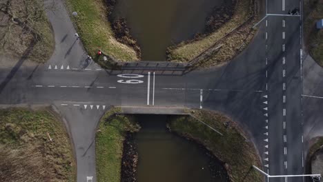 Drone-shot-zooming-out-on-crosspoint-with-traffic-going-down-the-roads