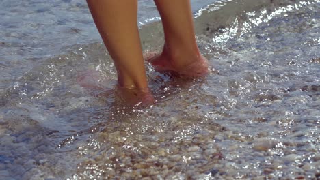 Frau-Benetzt-Ihre-Füße-Am-Ufer-Des-Mittelmeers-An-Einem-Kiesstrand
