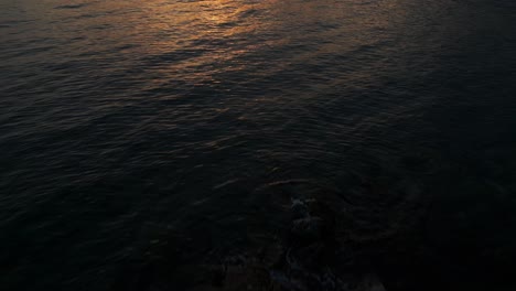 Orange-Sunset-Light-Reflected-On-Liguarian-Sea-With-Silhouette-Of-Coastliine