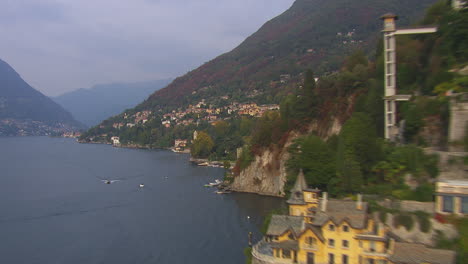 Aerial-exploration-shot-of-the-waterfront-apartments-sitting-on-the-mountainside-at-Lake-Como