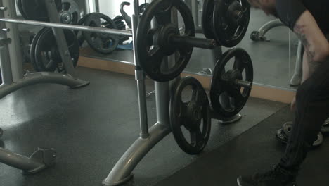Close-Up-of-a-Man-Adding-Weights-to-a-Machine-at-the-Gym