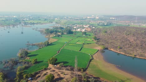 Aerial-drone-flight-over-a-village-farmland-surrounded-by-backwaters-of-Gwalior-in-india