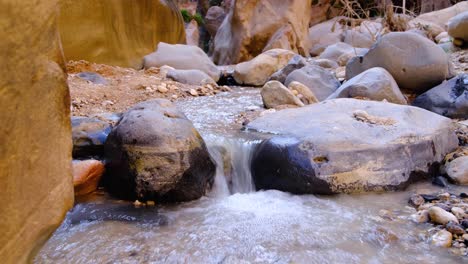 Scenic-freshwater-stream-with-flowing-water-over-small-rocky-cascades-in-natural-outdoorsy-nature-environment