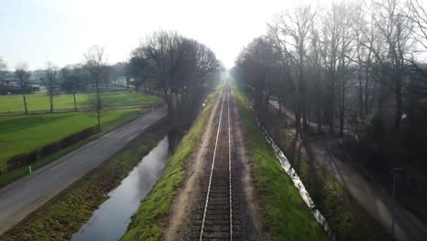 Drone-shot-following-a-railroad-through-nature-without-train
