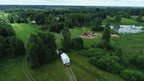 Transporting-a-prefabricated-cabin-or-trailer-to-put-on-a-foundation-in-the-countryside---aerial-view