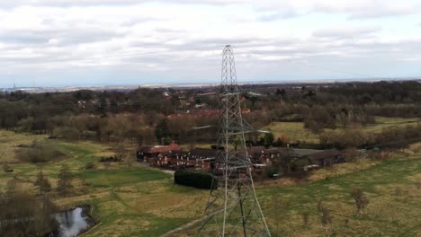 Flying-around-Electricity-distribution-power-pylon-overlooking-British-parkland-countryside
