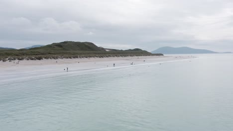 Ascending-drone-shot-of-Luskentyre-Beach-with-the-Harris-mountains-in-the-background