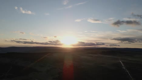 Aerial-footage-of-a-beautiful,-cloudy-sunset-over-rolling-hills-in-the-Peak-District,-UK