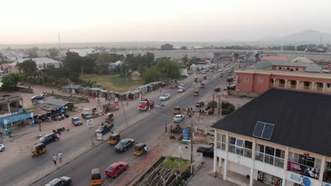 Tráfico-Típico-De-Taxis-De-Automóviles-Y-Motocicletas-Tuk-Tuk-En-La-Ciudad-De-Jalingo,-Nigeria---Vista-Aérea-Ascendente