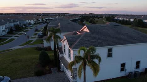Aerial-view-in-front-of-a-luxury-villa,-sunset-in-a-neighborhood-of-Orlando,-Florida---reverse,-tilt,-drone-shot