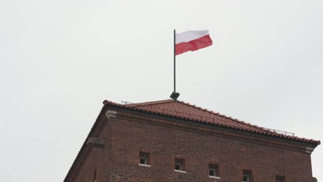 Royal-Wawel-Castle-and-Gothic-Cathedral-in-Krakow,-Poland,-With-Sandomierska-and-Senatorska-Towers,-Polish-Flag-on-the-Tower