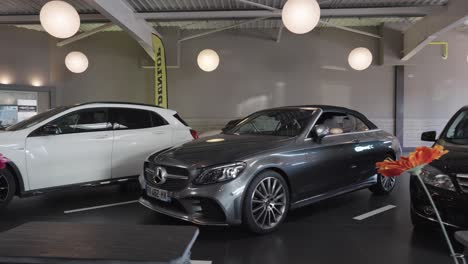Dolly-shot-revealing-the-wide-range-of-Mercedes-Benz-cars-on-sale-in-a-showroom