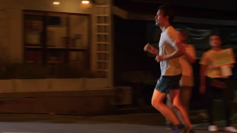 Happy-running-man-clapping-during-the-night-time-Samui-run