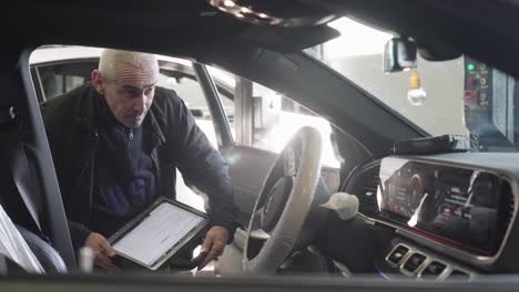 Un-Técnico-Mira-El-Tablero-Del-Mercedes,-Enchufó-Una-Baliza