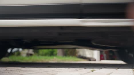 Street-level-shot-of-car-leaving-driveway-moving-out-of-frame