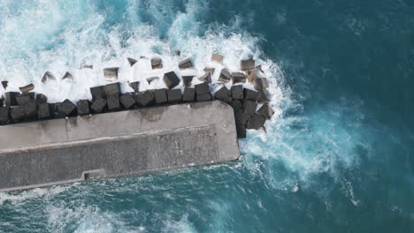 Orbit-Shot-Of-Waves-Crashing-On-Pier-Rocks,-Puerto-De-La-Cruz,-Spain