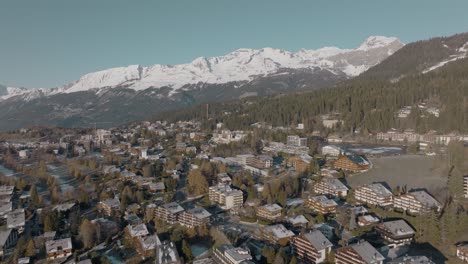Tilting-aerial-over-alpine-houses-of-beautiful-rich-mountain-resort-Crans-Montana,-Switzerland