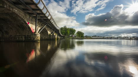Zeitraffer-Von-Carrick-Auf-Der-Shannon-Town-Bridge-In-Der-Grafschaft-Leitrim-Und-Roscommon-Mit-Verkehr,-Menschen-Und-Ziehenden-Wolken-Am-Fluss-Shannon-In-Irland