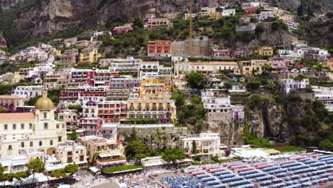 Aerial-drone-footage-of-Marina-Grande-beach,-chiesa-of-Santa-Maria-Assunta-in-Positano,-Amalfi-coast,-Campania,-Italy