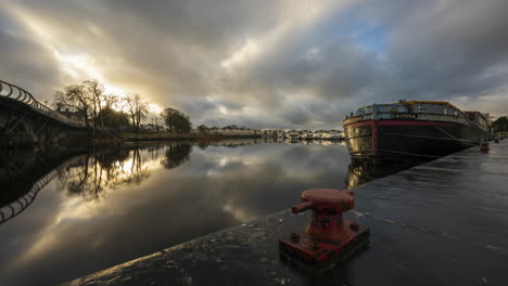 Timelapse-of-Carrick-on-Shannon-town-bridge-in-county-Leitrim-and-Roscommon-with-traffic,-people-and-moving-sunset-evening-clouds-on-river-Shannon-in-Ireland