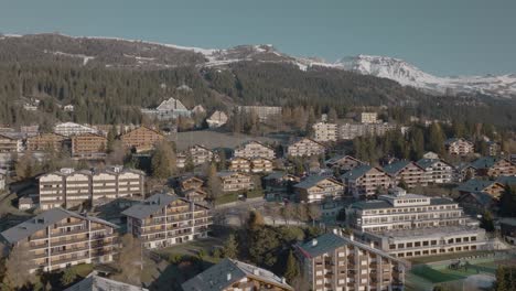 Rotierende-Antenne-über-Alpenhäusern-Des-Wunderschönen-Bergresorts-Crans-Montana,-Schweiz