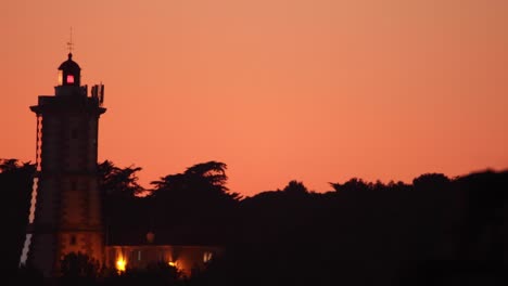 Sonnenuntergang-Malt-Den-Himmel-In-Mehreren-Rottönen-Mit-Leuchtturmsilhouette,-Cascais,-Portugal