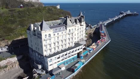 Aerial-view-of-The-Grand-hotel-landmark-Llandudno-seafront-seaside-Victorian-promenade-tourism-building-high-orbit-right