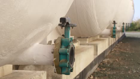 Close-up-rack-focus-across-the-valves-on-the-outdoor-tanks-of-the-desalination-water-treatment-plant-on-the-coast-of-Paphos,-Cyprus