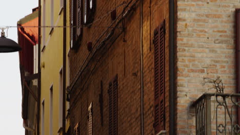People-in-the-streets-of-Ferrara,-Italy,-UNESCO-World-Heritage-Site,-tilt-down