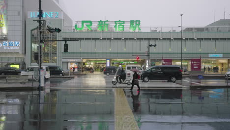 Tráfico-Conduciendo-En-Carretera-Mojada-Frente-A-La-Estación-Shinjuku-Jr-Después-De-Nevar-Y-Llover-En-Tokio,-Japón