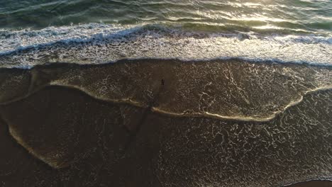 Aerial-top-down-of-man-fishing-on-a-beach-at-sunrise-in-Southport-Gold-Coast-QLD-Australia
