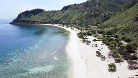 Aerial-drone-of-people,-adults,-children,-kids-walking-on-secluded,-remote-beach-on-tropical-island-Timor-Leste,-South-East-Asia