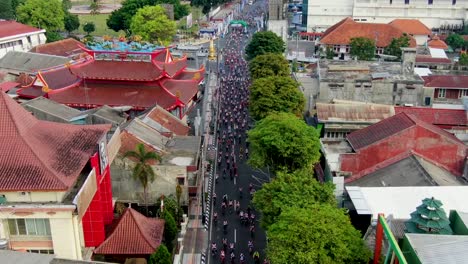 Cycling-road-race-aerial-view,-bicycles-riding-down-Magelang-city-street