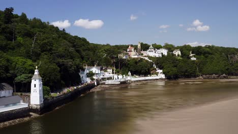 Drone-flying-past-Portmeirion-Village-on-the-Dwyryd-Estuary-in-North-Wales,-Britain,-UK