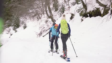 Couple-of-skiers-walking-together-on-snow-backcountry-landscape