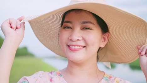 Porträt-Einer-Schönen-Asiatischen-Frau,-Die-Am-Reisetag-Ihren-Hut-Zurechtrückt