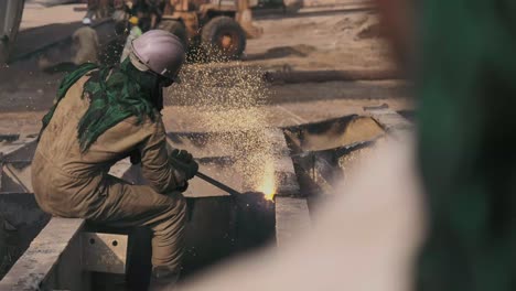 Over-The-Shoulder-Of-Male-Worker-Using-Acetylene-Torch-To-Cut-Metal-At-Gadani-Ship-Breaking-Yard