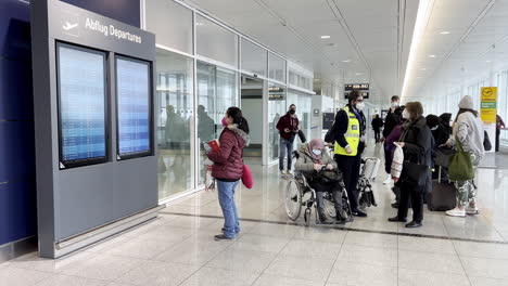 Los-Pasajeros-En-El-Aeropuerto-De-Munich-Leen-El-Sistema-De-Visualización-De-Información-De-Vuelo