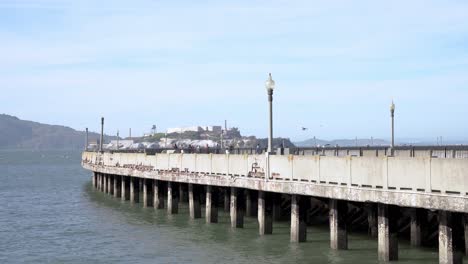 Gente-Caminando-Por-El-Muelle-Y-La-Isla-De-Alcatraz-Al-Fondo
