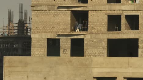 Workers-Standing-Seen-In-Empty-Room-At-Building-Site-In-Karachi