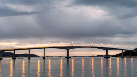 Nachts-Beleuchtete-Straßenlaternen-An-Der-Sommaroy-Brücke,-Die-Sich-Im-Wasser-In-Norwegen-Spiegeln