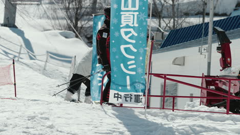 Esquiar---Esquiador-Masculino-Ralentizando-La-Colina-Hacia-La-Salida-De-La-Estación-De-Esquí-En-Okuhida-Hirayu,-Gifu,-Japón