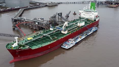 Silver-Rotterdam-chemical-oil-tanker-ship-loading-at-Tranmere-terminal-Liverpool-aerial-view-close-orbit-left