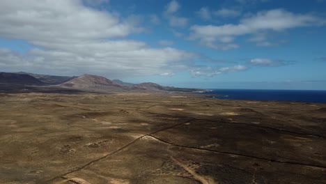 Aerial-view-of-mountains-and-volcanic-plains-in-Lanzarote,-Canary-Islands