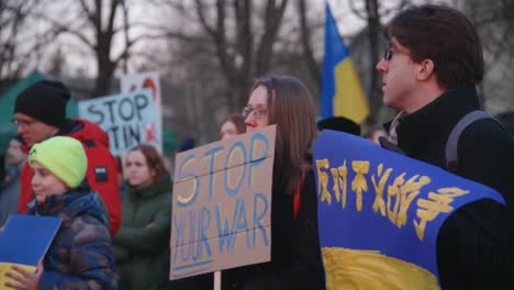 Una-Pareja-Joven-De-Pie-Con-Un-Cartel-De-Stop-Your-War-En-Protesta-En-Lituania
